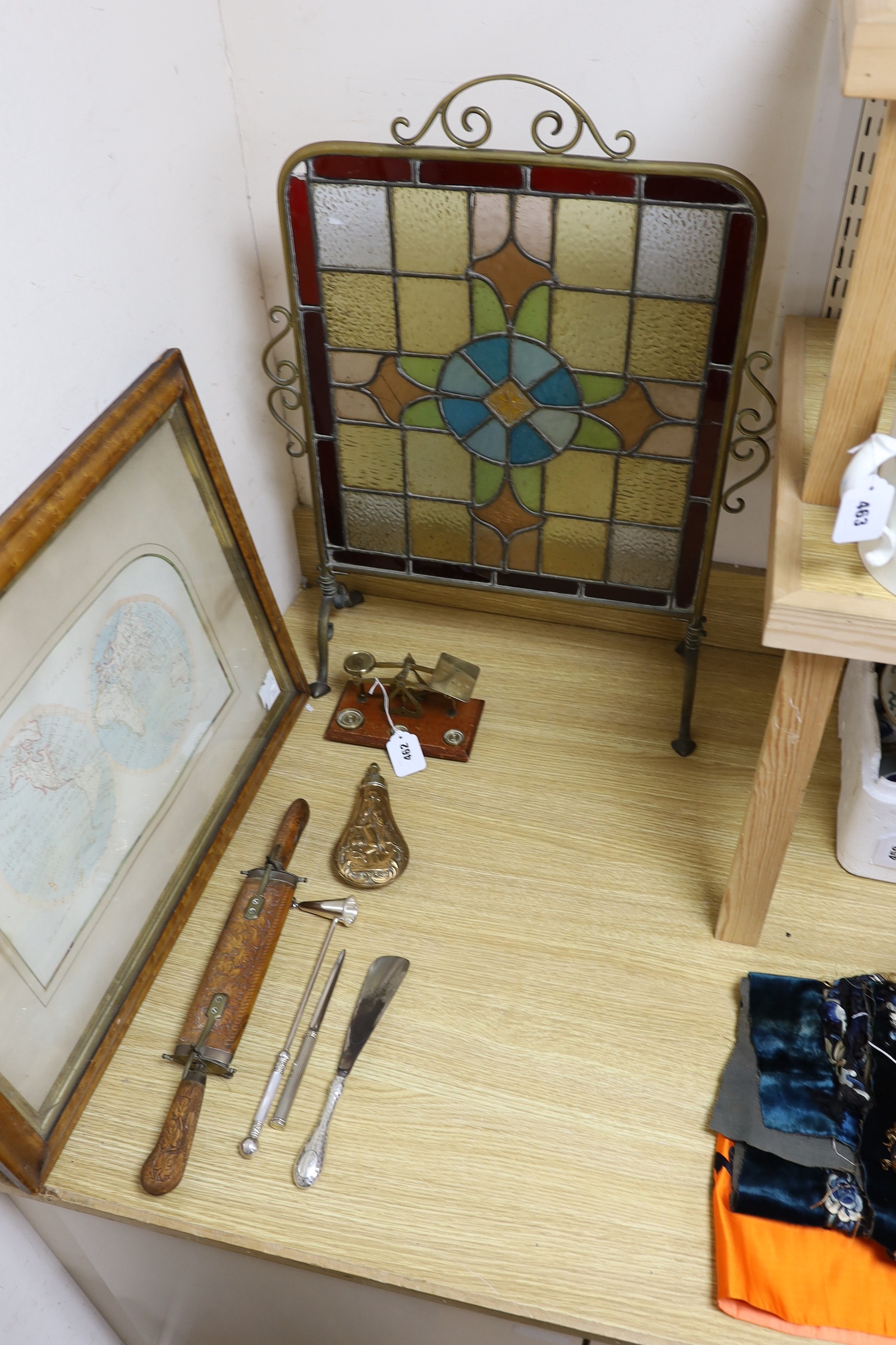 A Victorian embossed copper shot flask, postal scales and weights, plated items, a display knife and fork and a stained glass fireguard-55cms x 72cms high